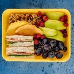 lunch box with fruit and sandwiches